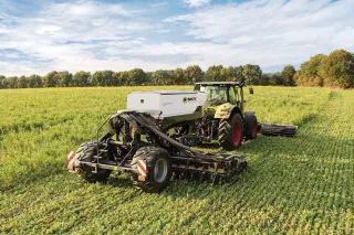 Traktor se secím strojem SKY na poli